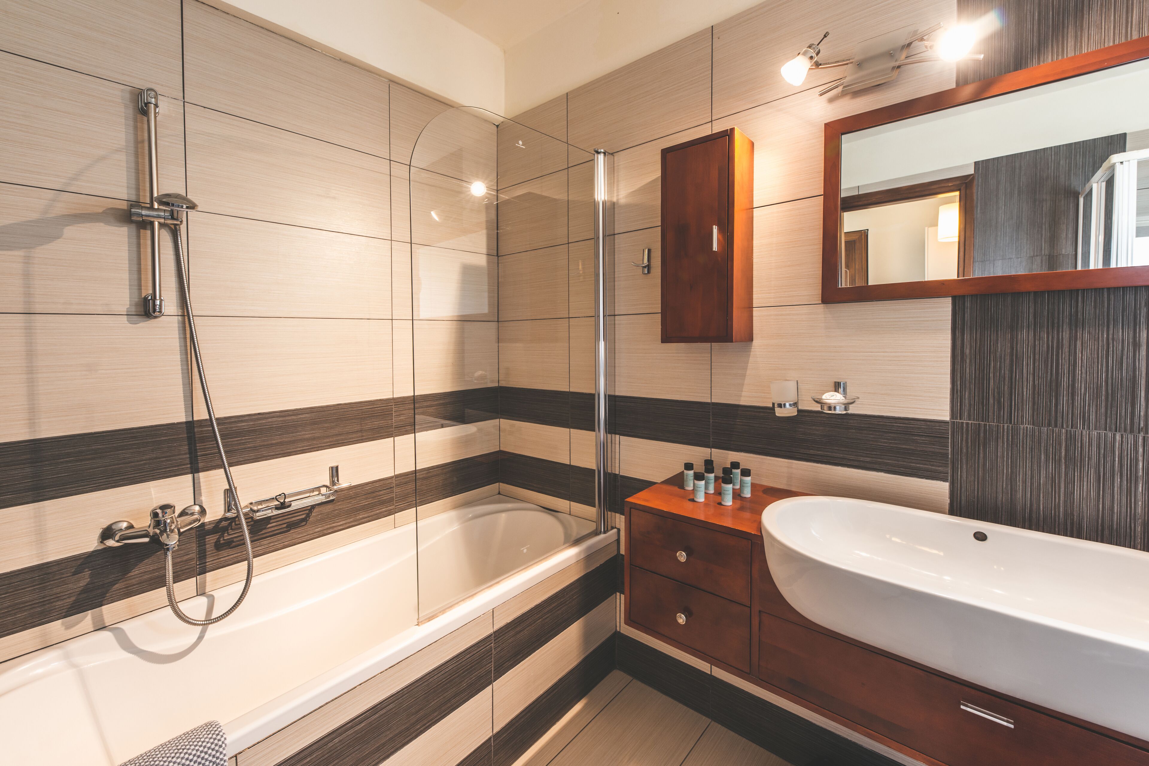 A modern bathroom with a bathtub, a shower, and a vanity with a sink.
