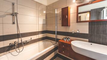 A modern bathroom with a bathtub, a shower, and a vanity with a sink.