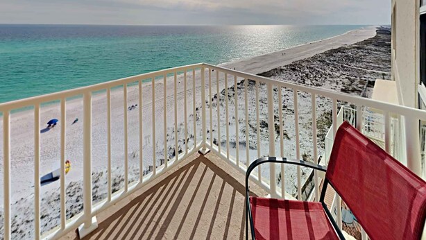 Un balcon avec vue sur une plage et l’océan.