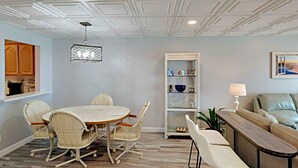 Un coin repas avec une table ronde et des chaises, une bibliothèque et un canapé.