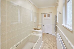 Bathtub, hair dryer, towels, shampoo