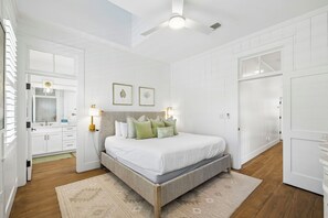 A bedroom with a bed, a ceiling fan, a nightstand, a dresser, and a mirror.