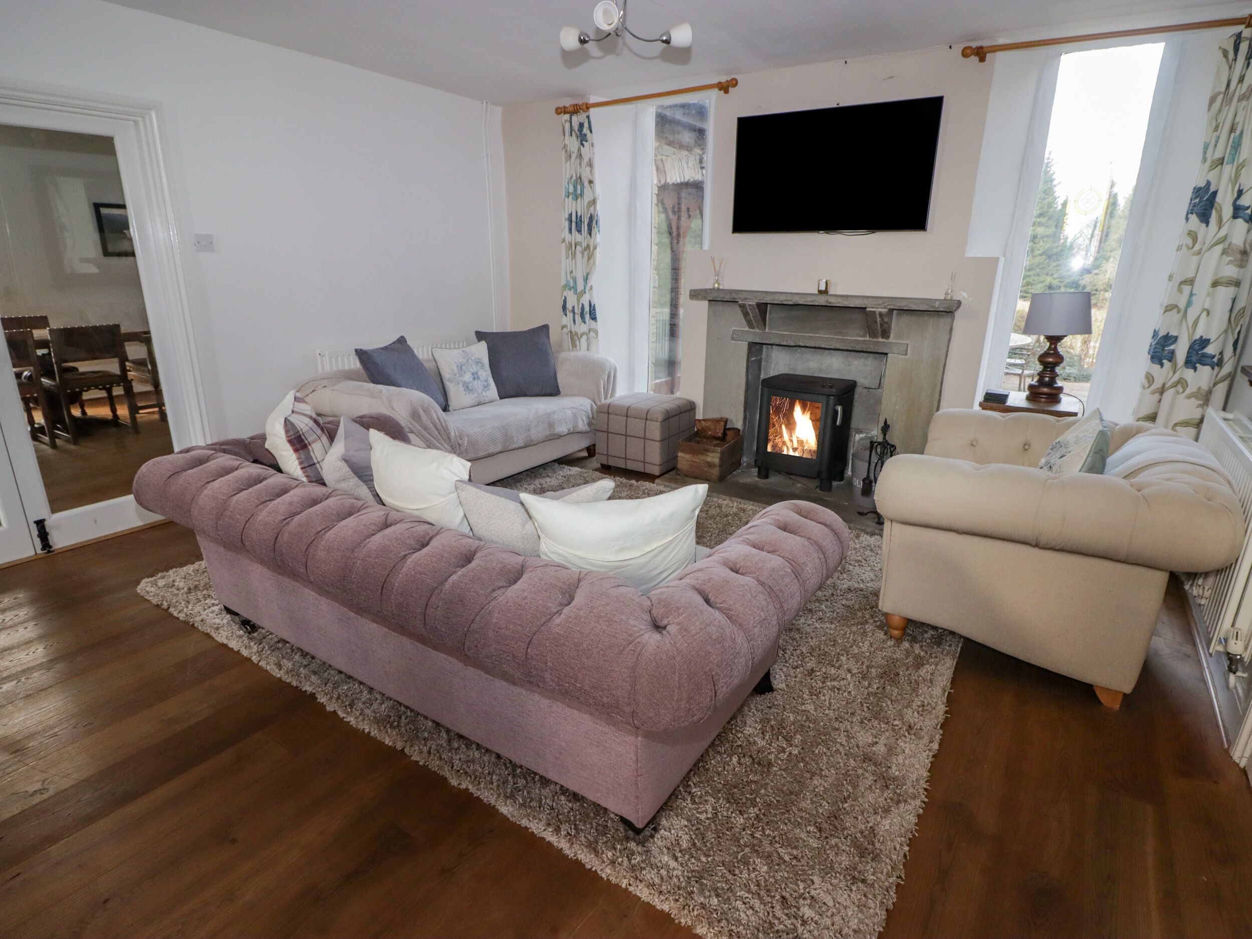 A living room with a fireplace, sofas, and a television.