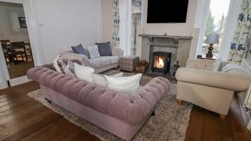 A living room with a fireplace, sofas, and a television.