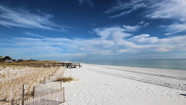 A beach with a wooden boardwalk leading to the water, sandy dunes, and a clear sky. - Azure 222 — Renovated 3BR Gulf-Side Condo with Beach Service (Fort Walton Beach)