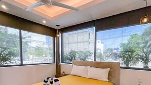 A hotel room with a bed, a nightstand, and a ceiling fan. - Modern Stay - Rooftop Pool - Walk to Beach & 5th (Playa del Carmen)