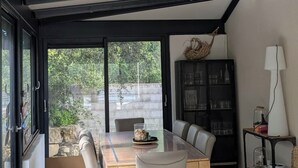A dining area with a table and chairs, a cabinet, and a lamp.