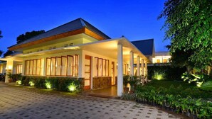 A modern building with a covered entrance and a garden area. - Blambangan Hotel (Banyuwangi)