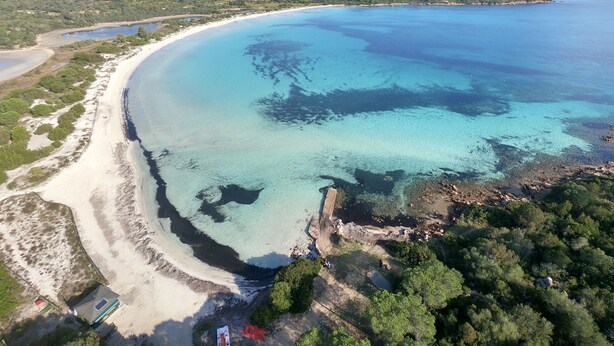An aerial view of a coastal area with a beach, clear waters, and a mountain in the background. - Domus Pedra trilocali  con A.C (San Teodoro)