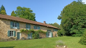 A stone house with a tiled roof, green shutters, and a well-maintained lawn. - Bed and breakfast - Le Bonheur du Périgord (Miallet)