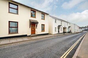 A row of two-story residential buildings with a flat roof, a front door, and windows. - 2 Bed in Braunton (oc-stepco) (Braunton)