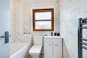 A bathroom with a toilet, sink, and bathtub. - 2 Bed in Braunton (oc-stepco) (Braunton)