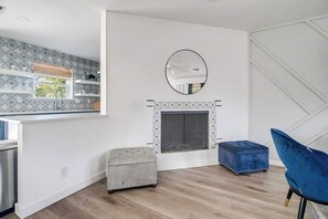 A modern kitchen with a built-in island, a fireplace, and a large window.