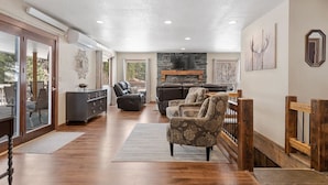 A spacious living area with a fireplace, leather sofas, and a view of the outdoors.