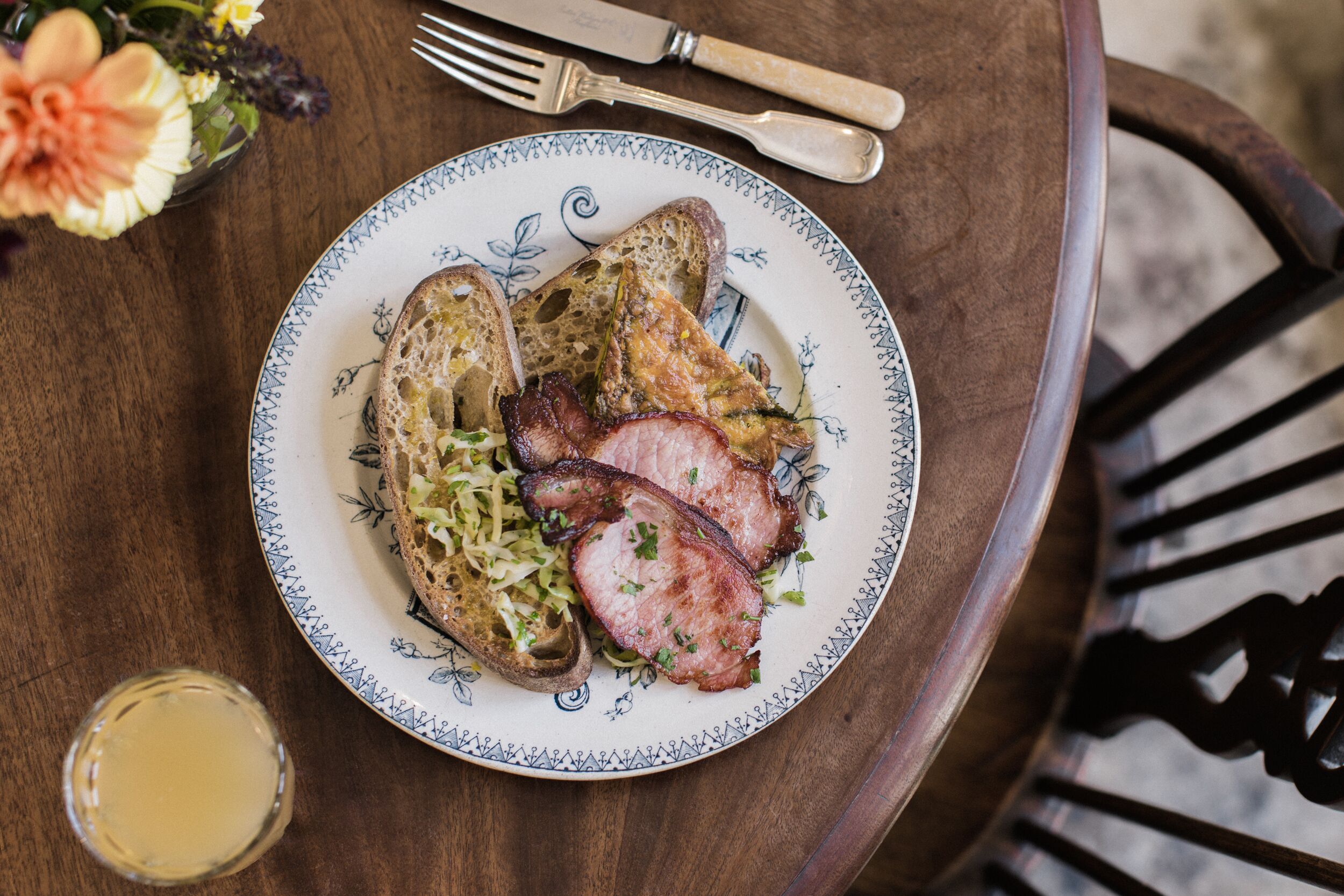 A plate with toasted bread, ham, and sauerkraut on a table.