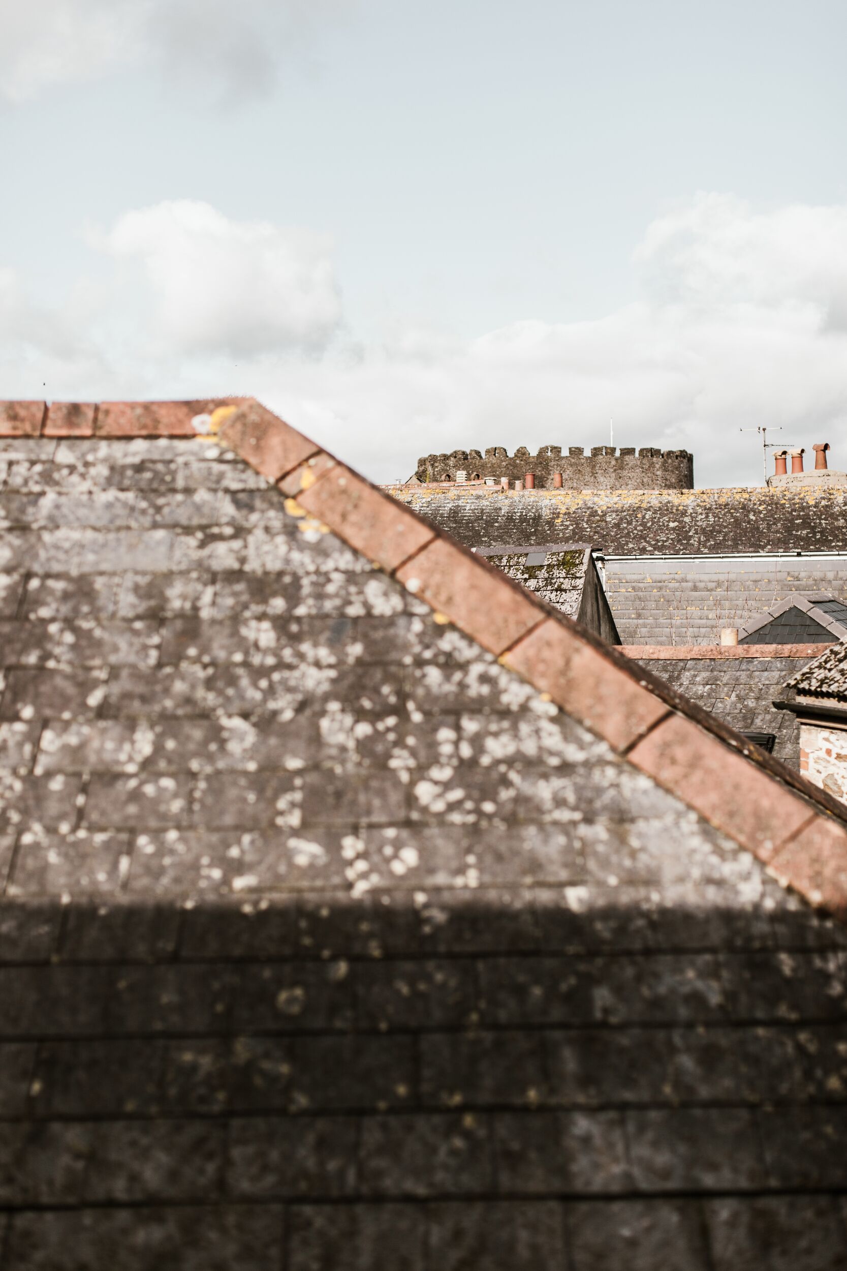 A rooftop with a brick parapet overlooking a historic fortification.