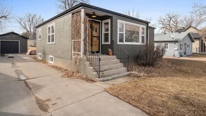 A single-story house with a front door, a small porch, and a driveway leading to a garage. - Walk to Parks- Pet Friendly-Top Neighborhood (Rapid City)
