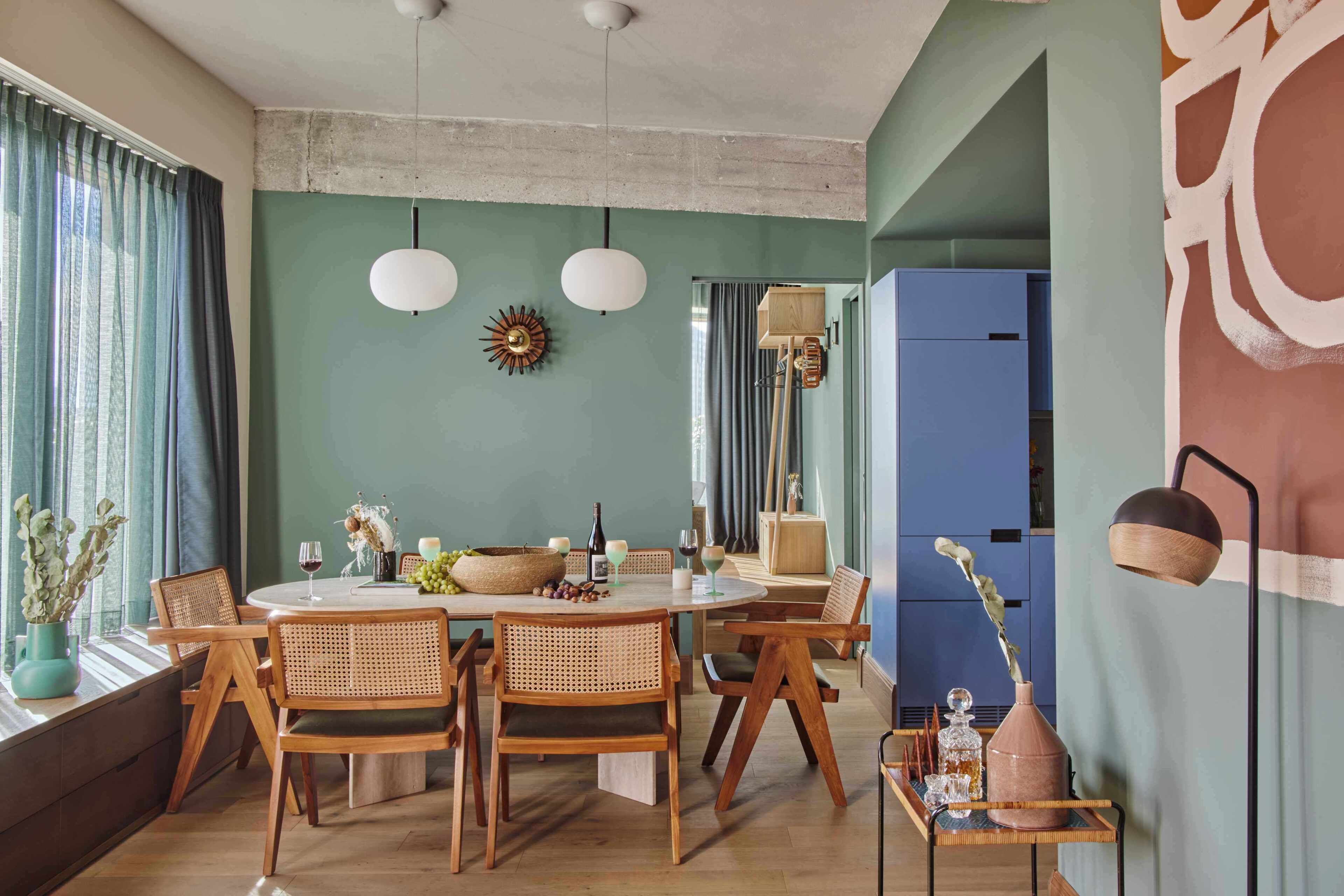 Un coin repas avec une table ronde, des chaises en bois et un luminaire suspendu au plafond.