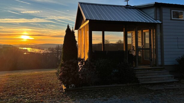 Ett hus med en inglasad veranda och en satellitmottagare.