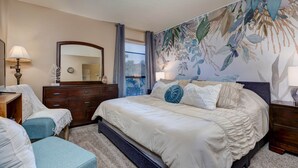 Une chambre à coucher avec un grand lit, une commode, un miroir et une fresque murale à motifs floraux.