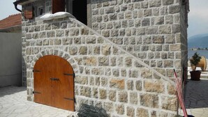 Ein Steinhaus mit Holztür und kleinem Fenster.