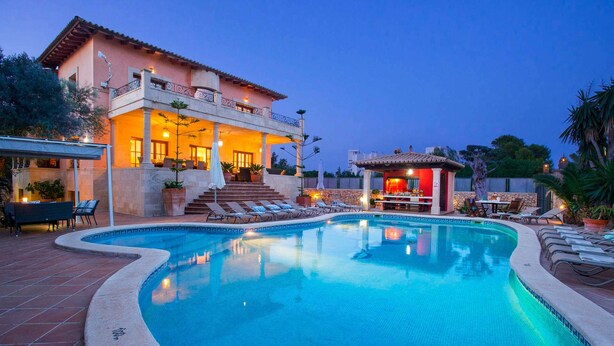 A swimming pool with lounge chairs and a bar area, surrounded by a building with a balcony and outdoor seating. - Oliveres - Six Bedroom Villa, Sleeps 12 (Pollença)