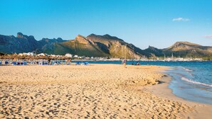 A beach with clear skies, a sandy shore, and a backdrop of rocky mountains. - Oliveres - Six Bedroom Villa, Sleeps 12 (Pollença)