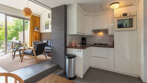 Eine moderne Küche mit weißen Schränken, einem Gasherd und einer Kaffeemaschine.