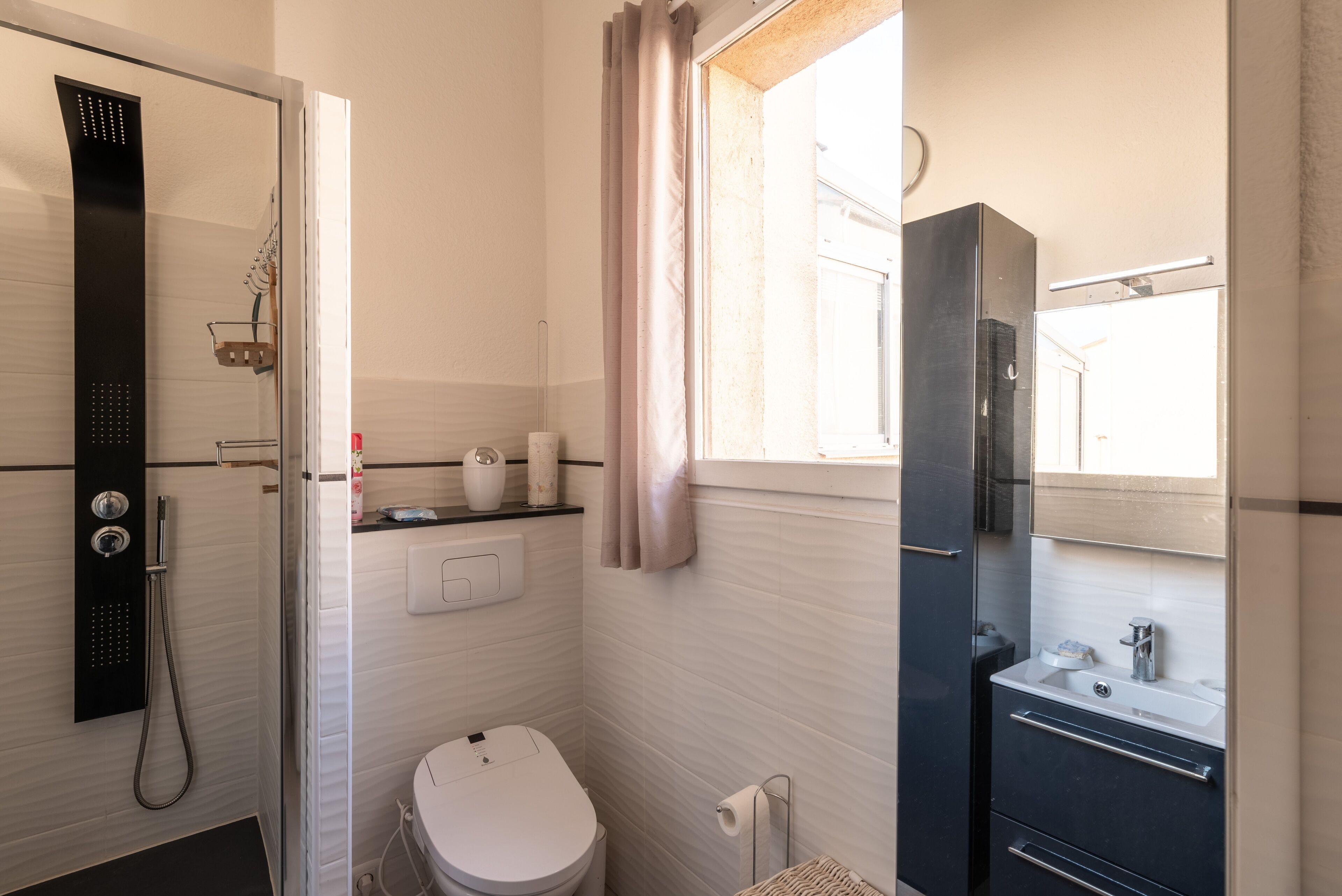 A bathroom with a shower, toilet, and sink.