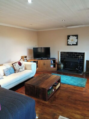 Relax in this stylish living room with a flat-screen TV, comfortable sofa, and cozy fireplace.