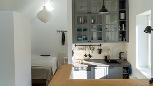 Une cuisine compacte dotée d’un plan de travail en bois, d’un évier encastré et de placards gris.
