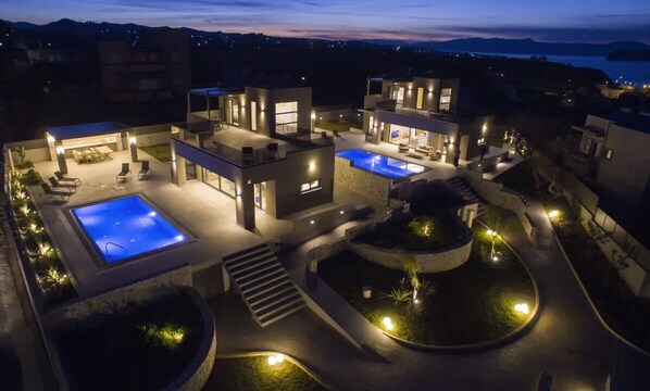 Une villa moderne dotée de deux piscines, d’un patio couvert et d’un jardin aménagé.