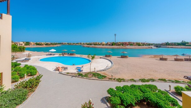 A resort with a large pool, beach area, and clear blue sky. - Vesta - Luxury APT - 1BR - Sabina (El Gouna)