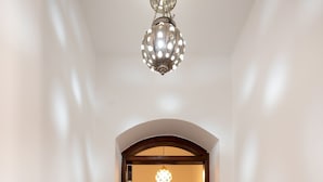 A hallway with a wooden door frame, a chandelier, and a tiled floor. - Vesta - Luxury Villa - 4BR - North Golf (El Gouna)