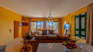 A living room with a sofa, a glass coffee table, and a fruit bowl. - Vesta - Superior APT - 4BR - Marina (El Gouna)