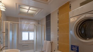 A modern bathroom with a skylight, a built-in washer and dryer, a toilet, and a sink. - Vesta - Superior APT - 4BR - Marina (El Gouna)