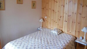 A bedroom with a wooden headboard, a bed with floral bedding, two bedside tables with lamps, and framed pictures on the wall. - 200m from ski slopes, 4th floor, balcony, tv, ski locker, 60m², Champagny-en-Vanoise (Champagny-en-Vanoise)