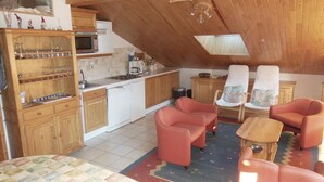 A cozy attic room with wooden cabinets, a microwave, a coffee maker, and two chairs. - 250m from resort center, 1st floor, balcony, tv, ski locker, 40m², Champagny-en-Vanoise (Champagny-en-Vanoise)