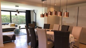 A modern dining area with a table set for six, surrounded by upholstered chairs. - RENOVATED vacation home by the sea Breskens10 pers. child friendly, dog welcome.  (Breskens)