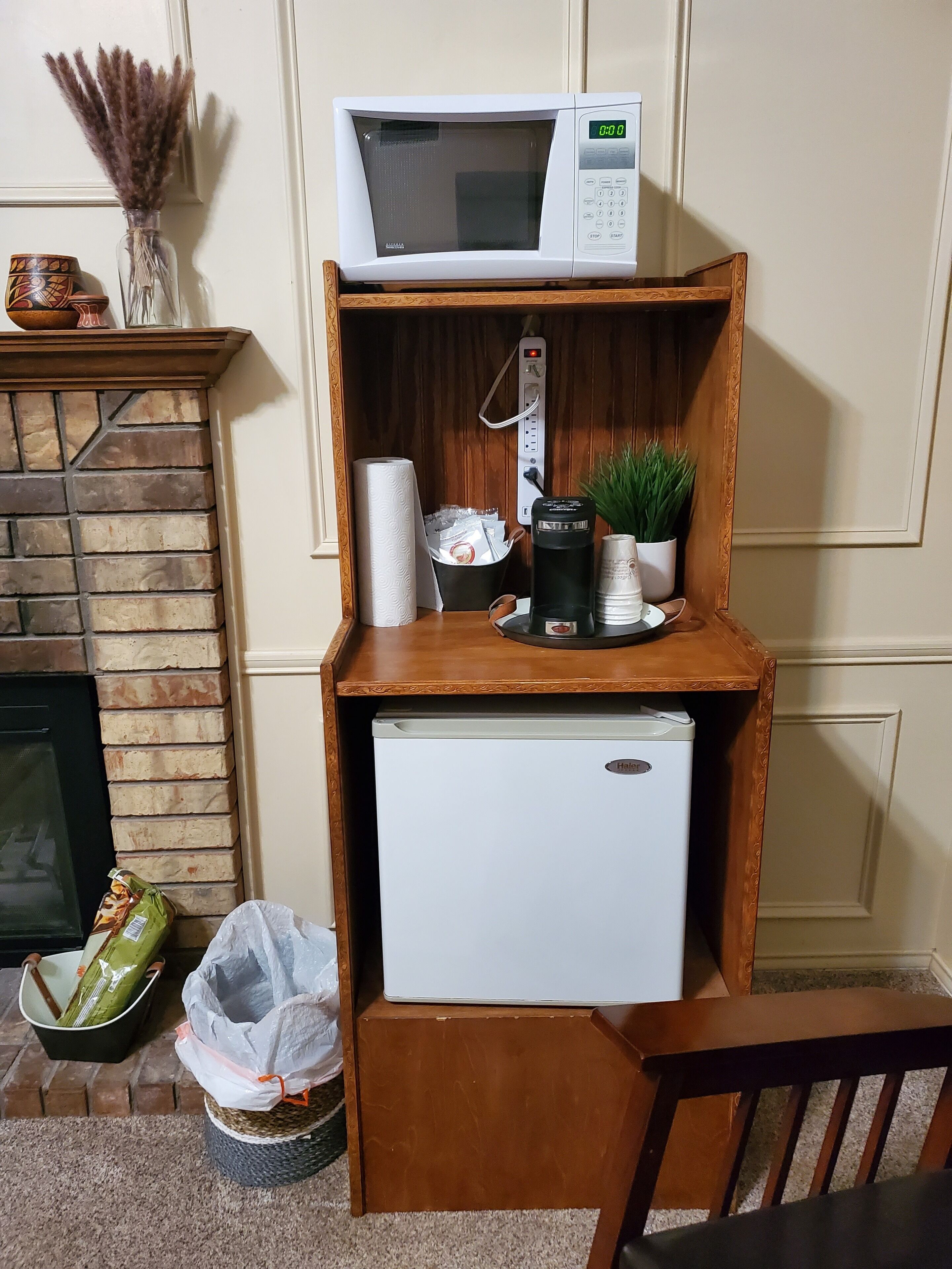 A compact kitchenette with a microwave, coffee maker, and a small refrigerator.