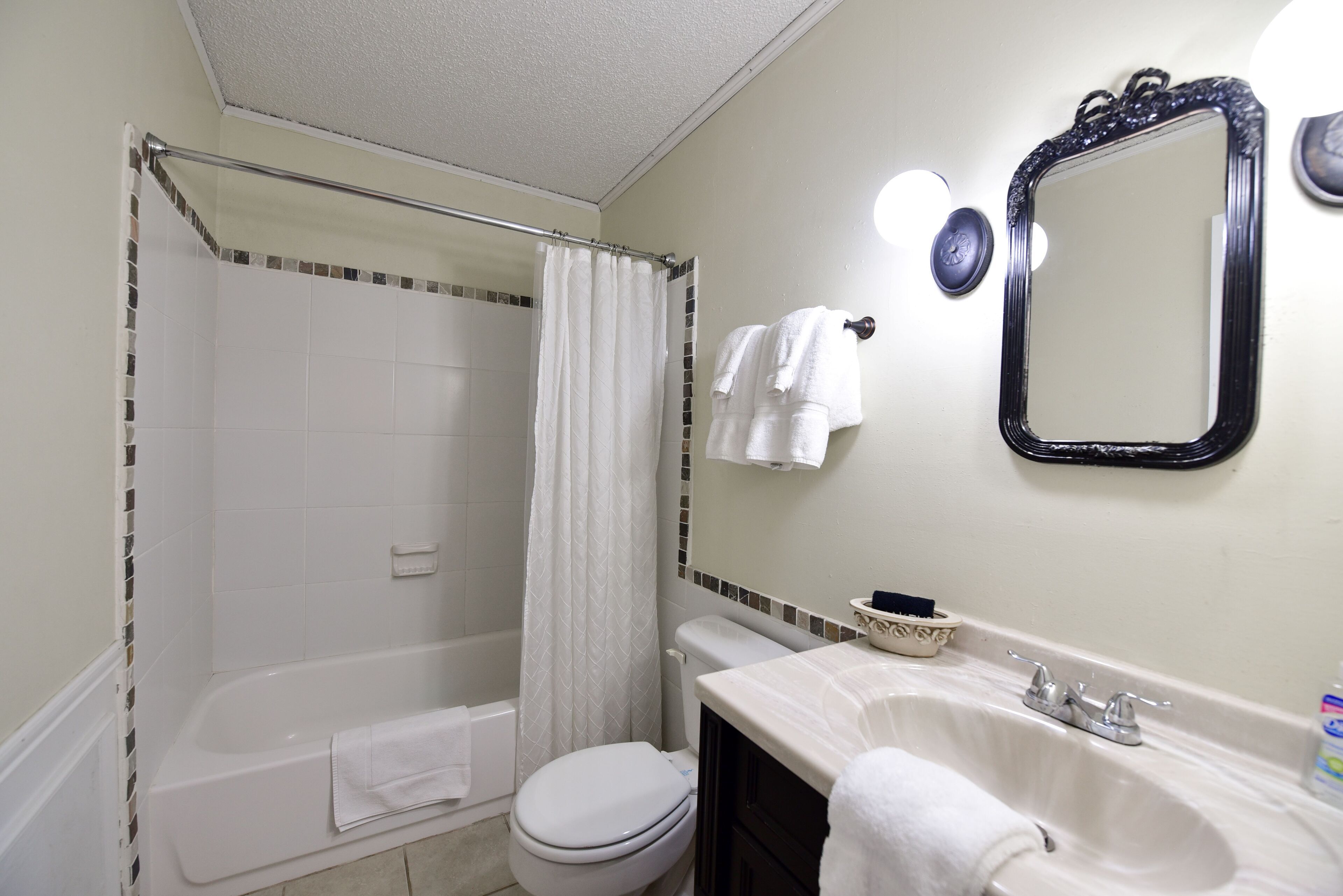 A bathroom with a bathtub, toilet, and sink.