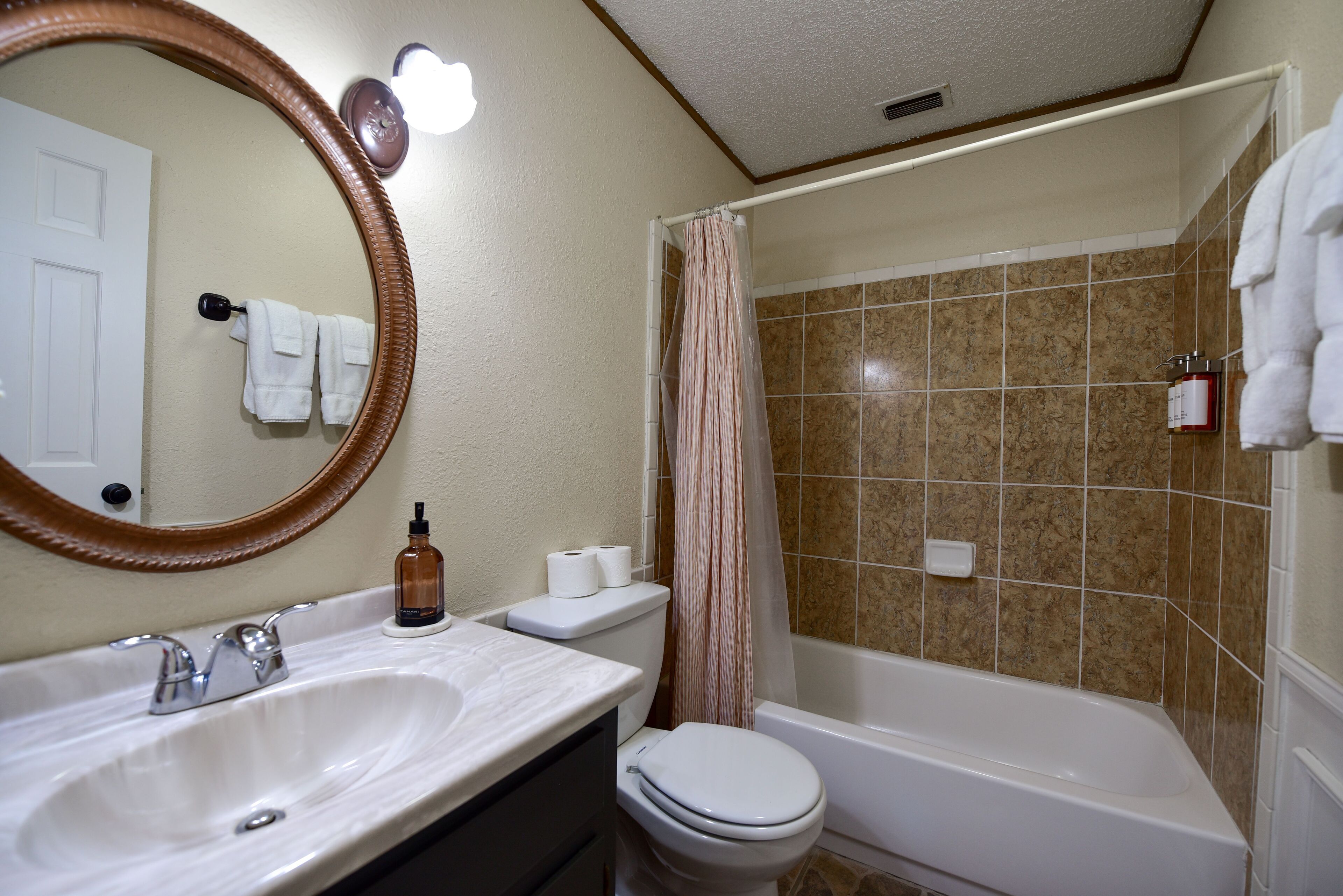 A bathroom with a white sink, a toilet, and a bathtub.