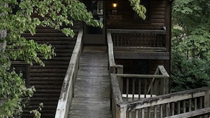 Une cabane en bois avec un escalier en bois menant à une véranda.