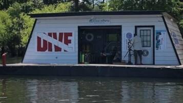 Un petit bateau à un seul étage, sur lequel on peut lire l’inscription « PLONGÉE », avec une porte et une petite fenêtre.