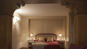 A hotel room with a large bed, two bedside tables, and a nightstand. - Hostal Rio Ara Bellosta (Fiscal)