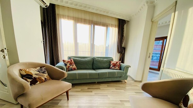 A living room with a green sofa, two armchairs, and patterned cushions. - Dolapdere Zona Apart (Istanbul)