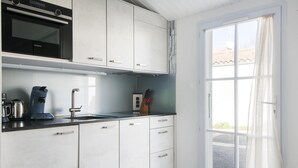 Une cuisine moderne avec des meubles blancs, un four noir et un évier.
