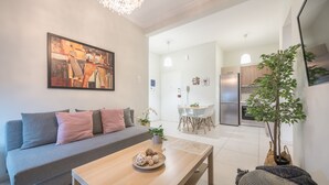 A modern living room with a sofa, coffee table, and a painting on the wall.