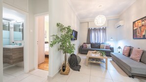 A modern living room with a sofa, coffee table, and a large plant.