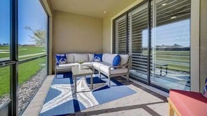 Un balcon avec un canapé, une table basse et un banc rouge.